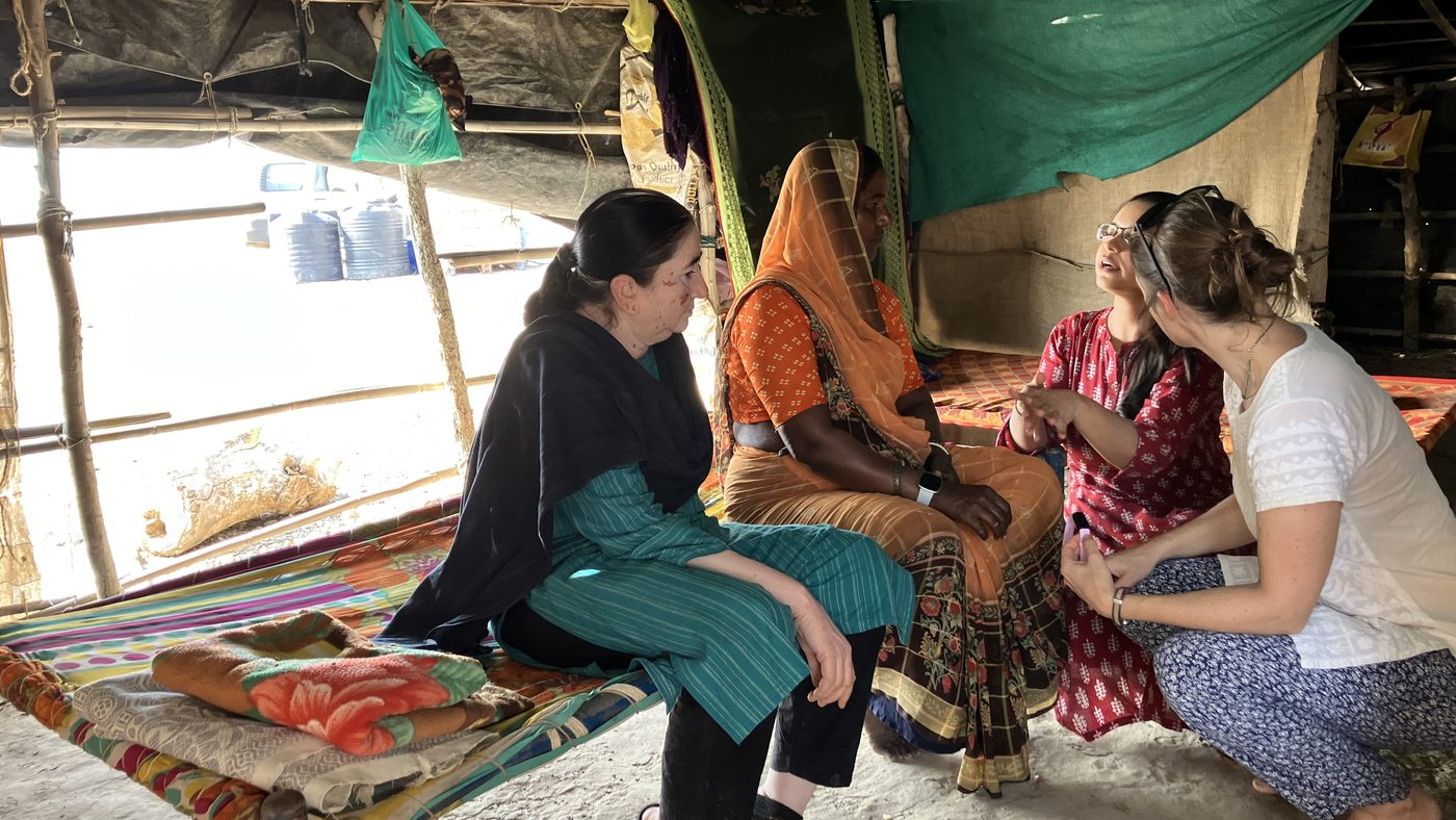 Researchers in conversation with SEWA workers inside a home during fieldwork.